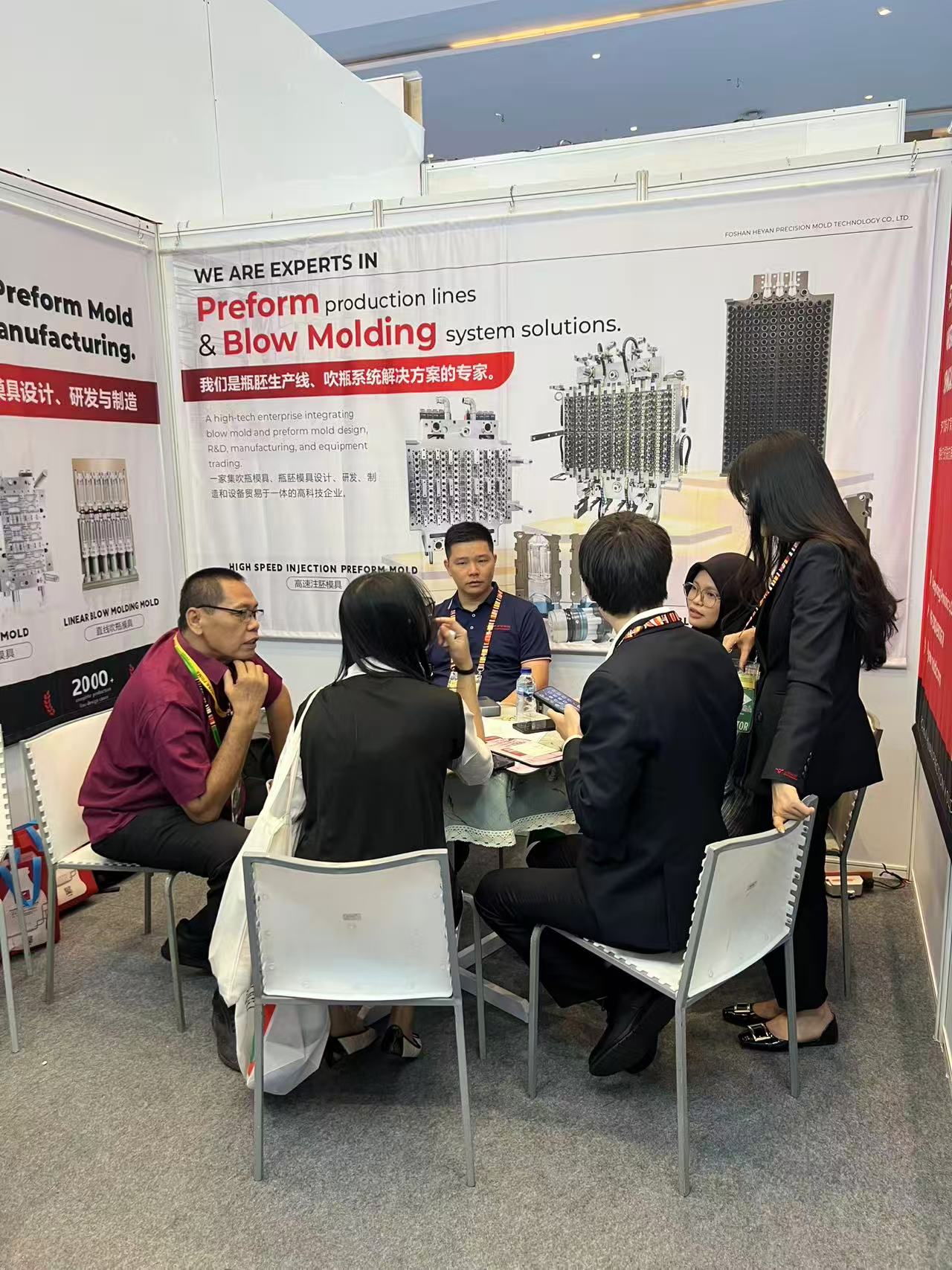 Heyan representative explaining PET preform mold options to a customer at ALLPACK Indonesia 2026